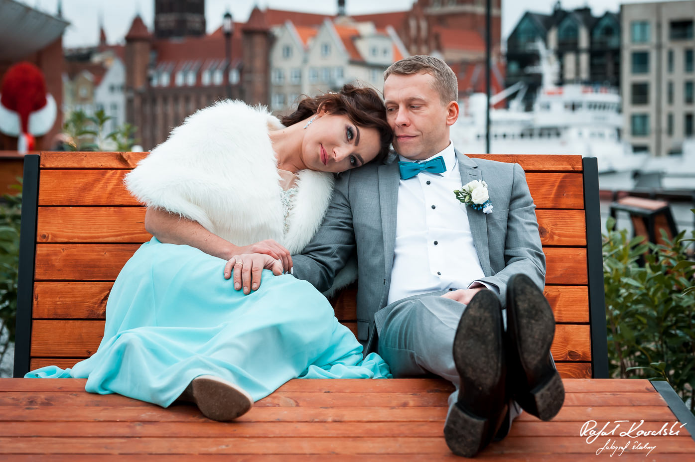 sesja zdjęciowa Gdańsk wtulona w siebie para młoda siedzi na drewnianej ławeczce nad Motławą