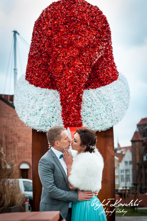 pocałunek na plenerowej sesji zdjęciowej w świąteczno zimowej scenerii Gdańska