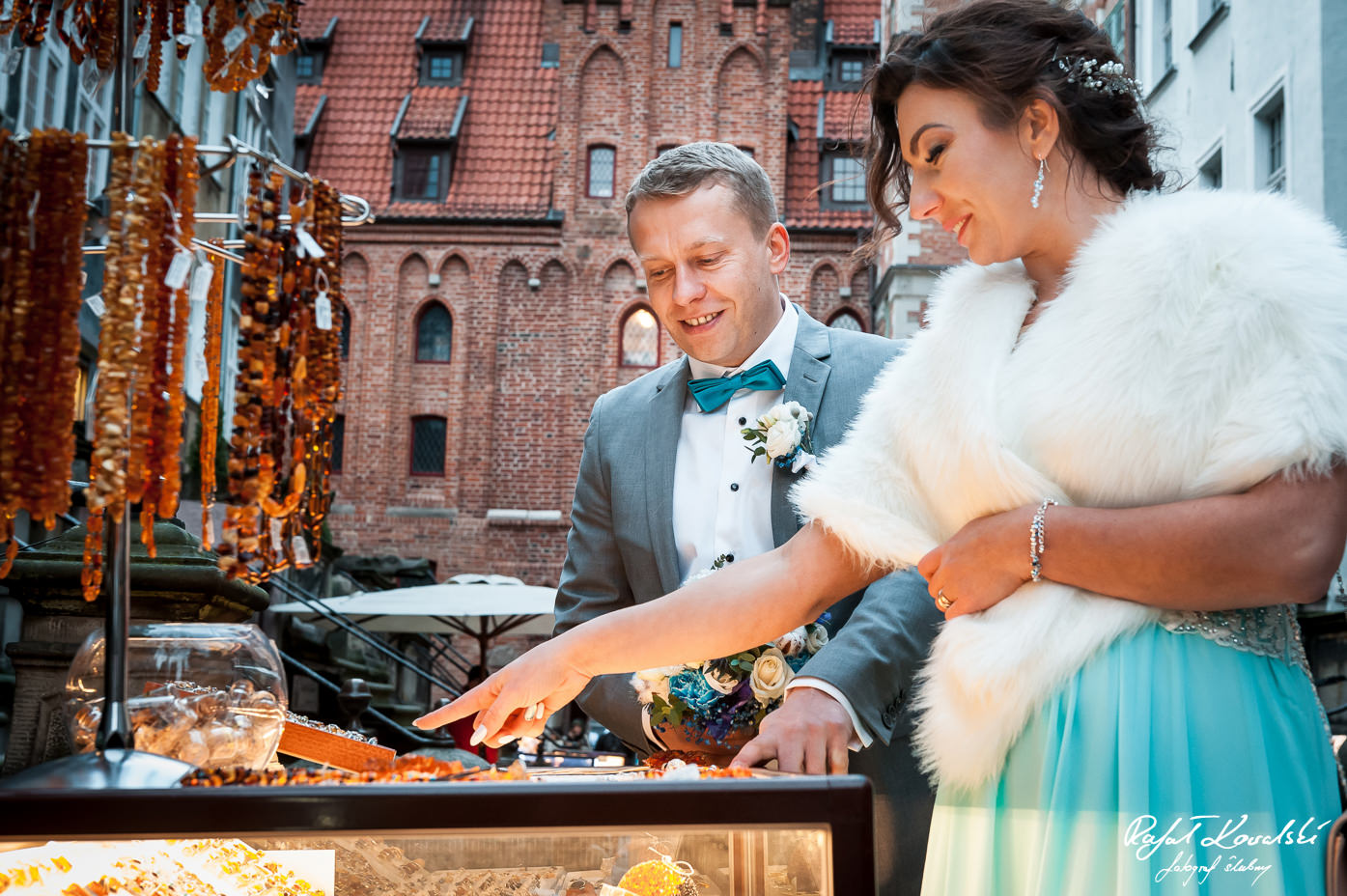 Sesja ślubna Gdańsk ciepłe światło od witryn z bursztynem na ulicy Mariackie oświetla parę młodą