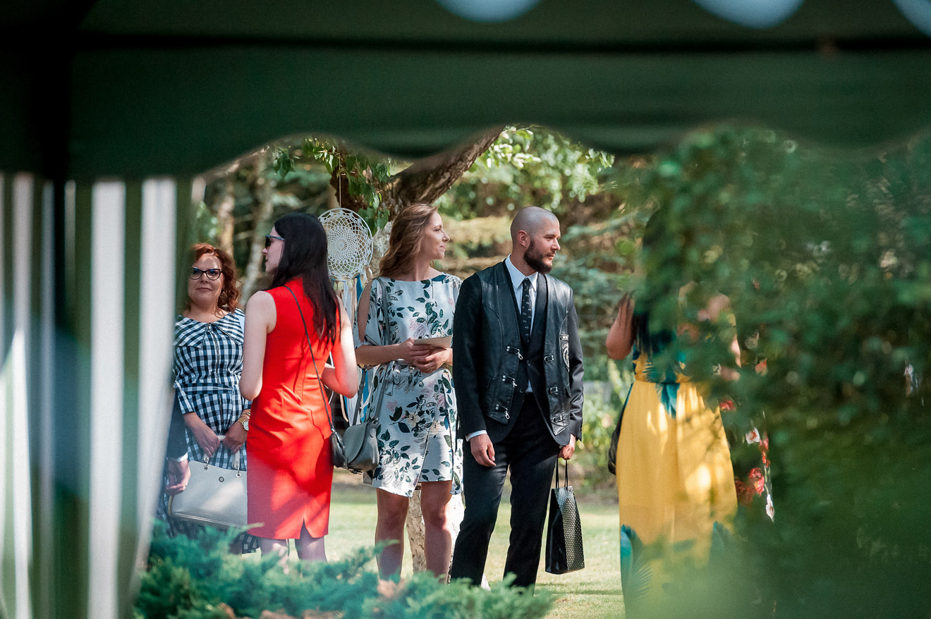 Goście weselni czekujący na ślub w plenerze